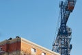 Construction of a brick house. Construction crane. Builders are laying bricks. Early morning. Cloudless blue sky. Royalty Free Stock Photo