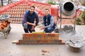 Construction, bricklayer and men building a brick wall, handyman or contractor with trade, mentor and apprentice in