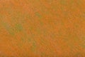 Construction of a bright orange background with light green spots of felt fabric, closeup. Texture of woolen matt textile. Cloth Royalty Free Stock Photo
