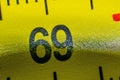 Construction bright yellow tape measure on a black background. Canvas roulette diagonal screen. The number 69 at roulette in macro Royalty Free Stock Photo