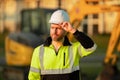 Construction build man with excavator at industrial site. Worker in helmet with bulldozer. Engineer work with builder Royalty Free Stock Photo