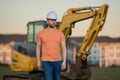 Construction build man with excavator at industrial site. Worker in helmet with bulldozer. Engineer work with builder Royalty Free Stock Photo