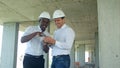 Construction builders smiling while using smartphone at site Royalty Free Stock Photo