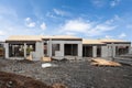 Construction of building of new white concrete houses with incomplete wooden roof.