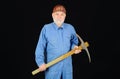 Construction and building works. Bearded man in coveralls and hard hat with pick-axe. Craftsman or contractor with Royalty Free Stock Photo