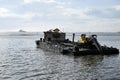 Construction bulldozer crane truck working, loaded on floating steel barge Royalty Free Stock Photo