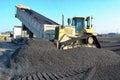 A construction bulldozer moving gravel