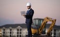 Construction business owner. Man in suit and hardhat halmet at building construction site. Civil engineer worker in