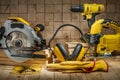 Construction carpentry tools electric corded circular saw jigsaw cordless drill earphones gloves goggles on wooden background Royalty Free Stock Photo