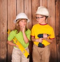 Construction children in helmets holding a drill and level . Cut Royalty Free Stock Photo