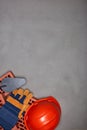 Stack of bricks with masonry trowel, construction hard hat, gloves on gray concrete background. Top view. Construction concept