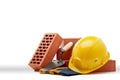 Stack of bricks with masonry trowel, construction hard hat and gloves on white background. Construction concept