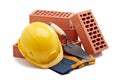 Stack of bricks with masonry trowel, construction hard hat and gloves on white background. Construction concept