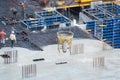 Construction of concrete foundation of new building. Aerial view of construction site workers leveling cement in