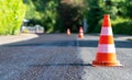 Construction cones marking part of road with a layer of fresh asphalt Royalty Free Stock Photo