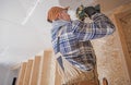 Construction Contractor Attaching Drywall Elements to the House Ceiling