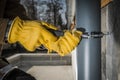 Construction Worker Attaching Home Gutters to the Building Wall