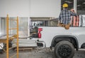 Construction Contractor Worker Taking Short Brake Seating on His Pickup Truck Cargo Bed Royalty Free Stock Photo