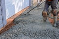 Construction contractors pouring wet concrete while paving a driveway as they work on a concrete construction project Royalty Free Stock Photo