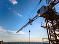 Construction crane on the background of a clear day sky aerial view. Flyby of a construction crane on a quadrocopter against the
