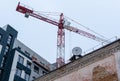 Construction crane on background of old and new houses Royalty Free Stock Photo