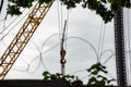 Construction crane behind a barbed wire fence, soft focus Royalty Free Stock Photo