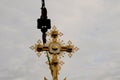 Construction crane with boom structure at construction site. The rise of the golden cross on the dome of the temple, gray cloudy Royalty Free Stock Photo