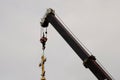 Construction crane with boom structure at construction site. The rise of the golden cross on the dome of the temple, gray cloudy Royalty Free Stock Photo