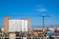 Construction crane and building frame on construction site against the background of residential development with multi-family Royalty Free Stock Photo