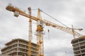 Construction crane builds new concrete shopping center buildings on construction site. Construction of new real estate. Royalty Free Stock Photo