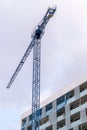 Construction crane and a corner of new modern building - details of construction Royalty Free Stock Photo