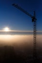 Construction crane in the fog at dawn Royalty Free Stock Photo