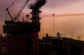 Construction crane, industrial building, construction, real estate during sunset. House infrastructure. New construction site with Royalty Free Stock Photo