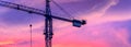 Construction crane isolated against clouds at sunset. Royalty Free Stock Photo