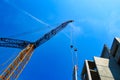 Crane lowering concrete slab onto building under construction.