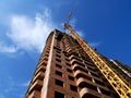 Construction crane near building on blue sky background. Royalty Free Stock Photo