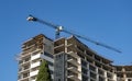 A construction crane near a high rise building under construction. Royalty Free Stock Photo