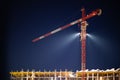 Construction crane in night illumination, construction of a multi-storey modern residential building. Night construction site, Royalty Free Stock Photo