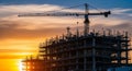 Construction Crane Silhouetted Against a Dramatic Sunset Sky Over a Building Under Construction Royalty Free Stock Photo