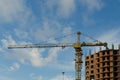 Construction crane on the construction site of a brick residential house Royalty Free Stock Photo