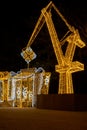 Construction crane symbol of Shipyard Holiday illuminated decorations in Gdansk Poland. Beautiful Christmas fair at