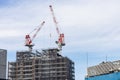 Construction crane on top of tower working to build high skycrapper office building in the development city, clear blue sky Royalty Free Stock Photo