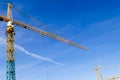 Construction crane tower on blue sky background. Crane and building working progress. Yellow lifting faucet. Empty Space for text. Royalty Free Stock Photo