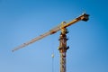 A Construction crane tower on blue sky background. Crane and building working progress. Yellow lifting faucet. Empty Space for Royalty Free Stock Photo