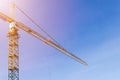 Construction crane tower on blue sky background. Crane and building working progress. Yellow lifting faucet. Empty Space for text Royalty Free Stock Photo