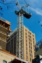 Construction crane with towering buildings in late afternoon sun in parking garage in downtown city san antonio texas