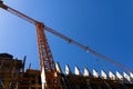 Construction crane towering over building site, construction of building still in progress Royalty Free Stock Photo