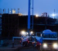 Construction crane truck working on structure at night