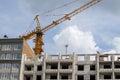 Construction crane on an unfinished residential building against the sun and blue sky. Housing construction, apartment building in Royalty Free Stock Photo