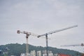 Construction crane and the upper part of the building with scaffolding on the background of the building under Royalty Free Stock Photo